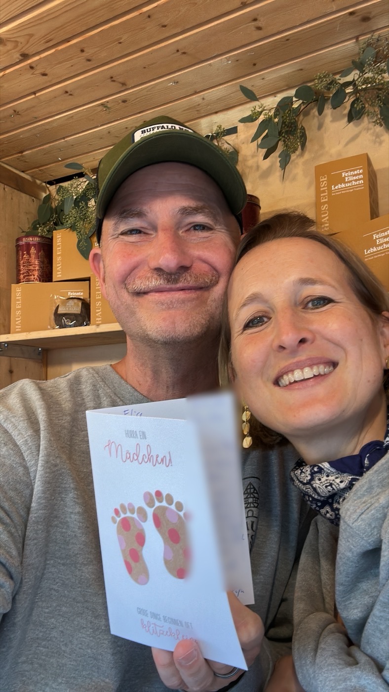 Christian Kn&ouml;fel und seine Frau Heidi halten eine Gl&uuml;ckwunschkarte mit der Aufschrift Hurra ein M&auml;dchen in die Kamera