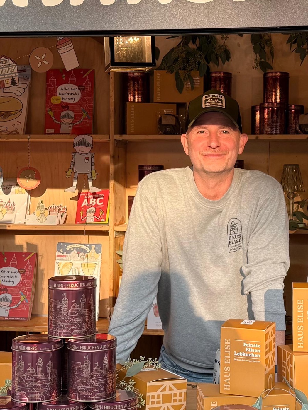 Christian Kn&ouml;fel hinter der Theke des HAUS-ELISE-Standes auf dem N&uuml;rnberger Altstadtfest, vor ihm Kaiserburg-Dosen und Geschenkboxen